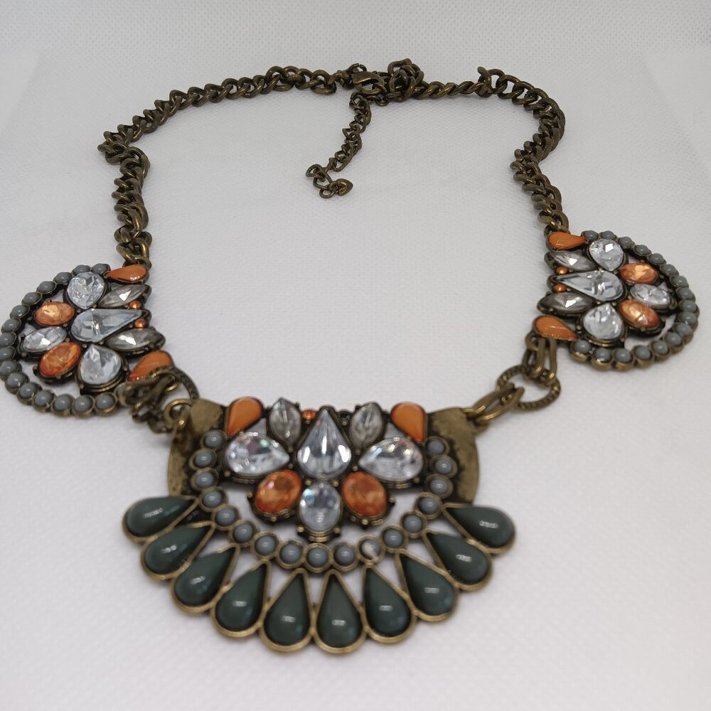 A  bronze necklace embellished with a mix of warm and cool colored stones.